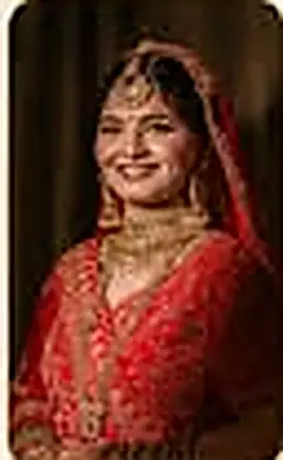 A bride in a red bridal lehenga and gold jewellery, smiling, cropped tightly from a small flyer inset.